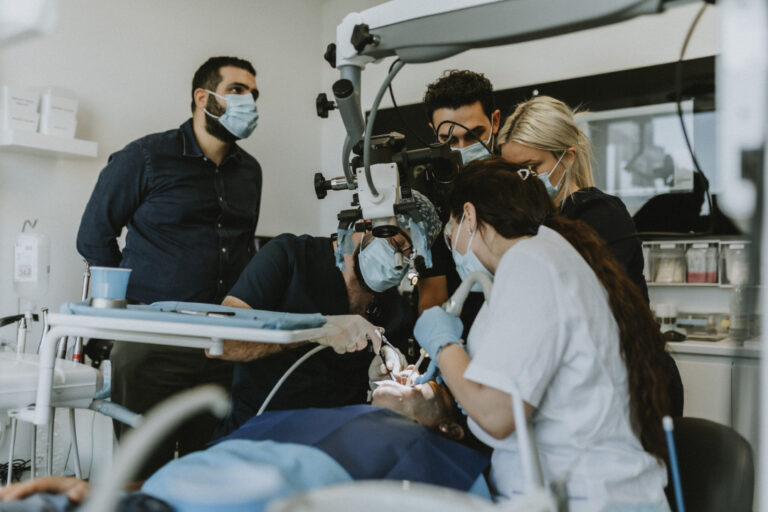 Dentist performing surgery with assistants in clinic.