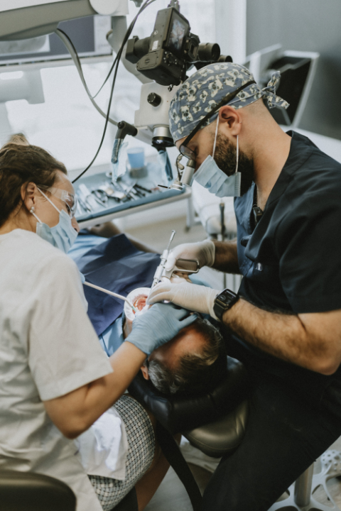 Dentists performing dental surgery on a patient.