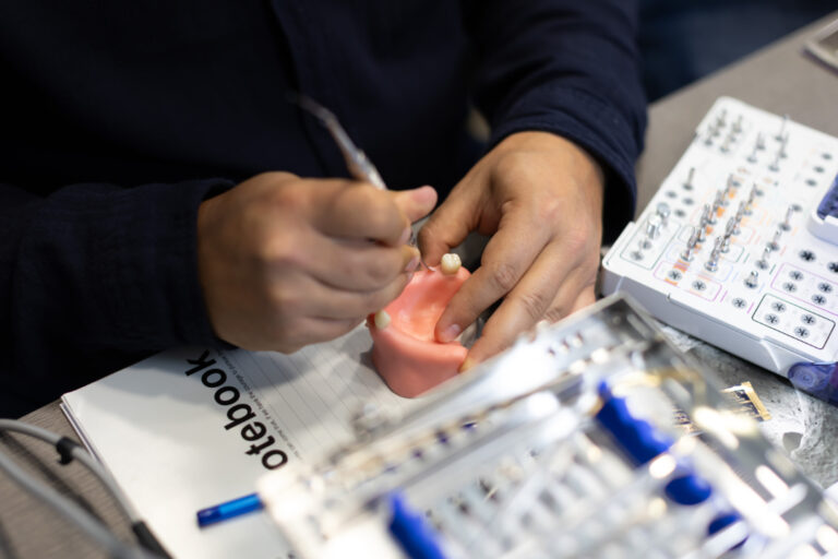 Person crafting dental model with tools